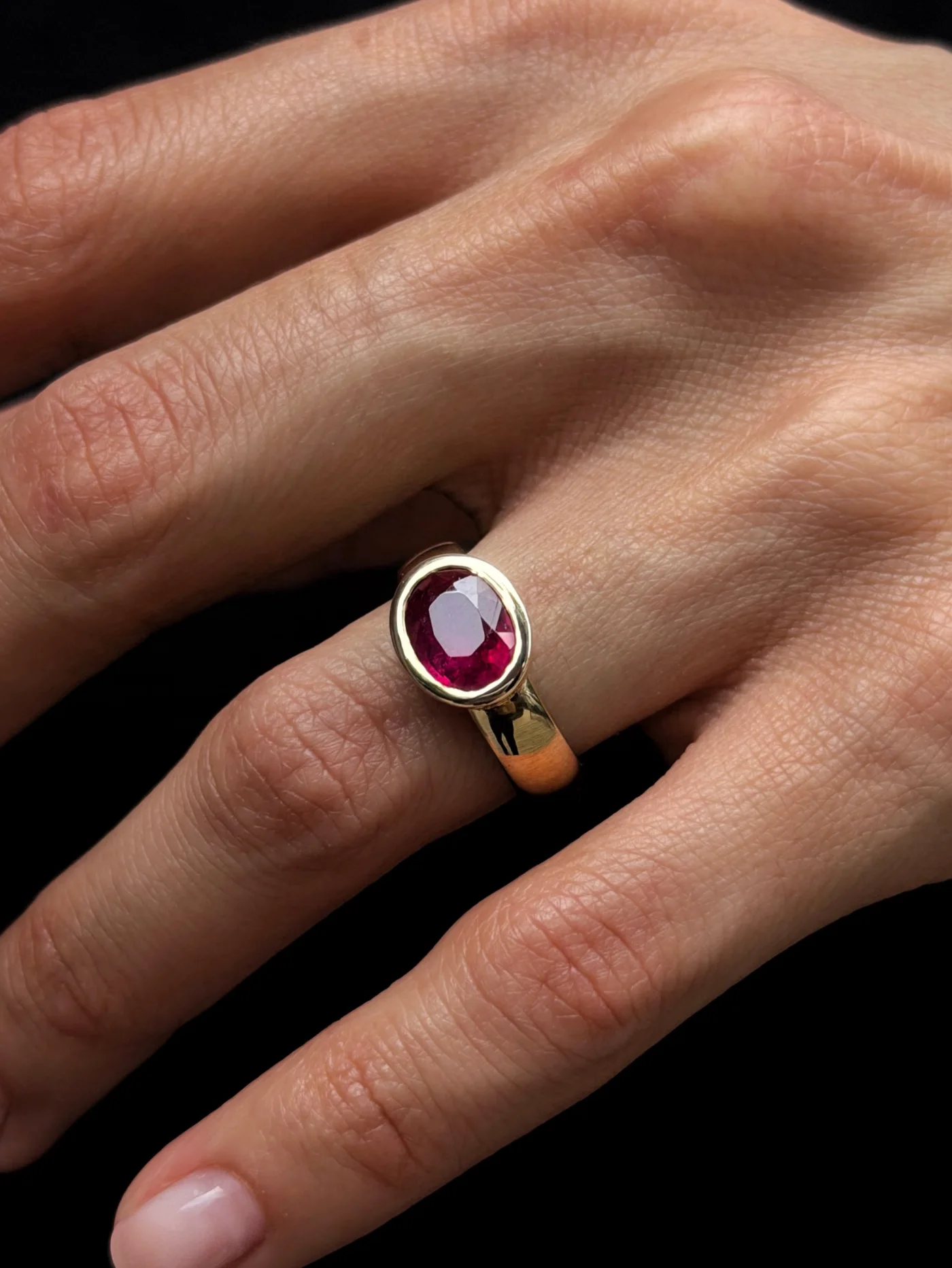Oval ruby ring in gold, worn