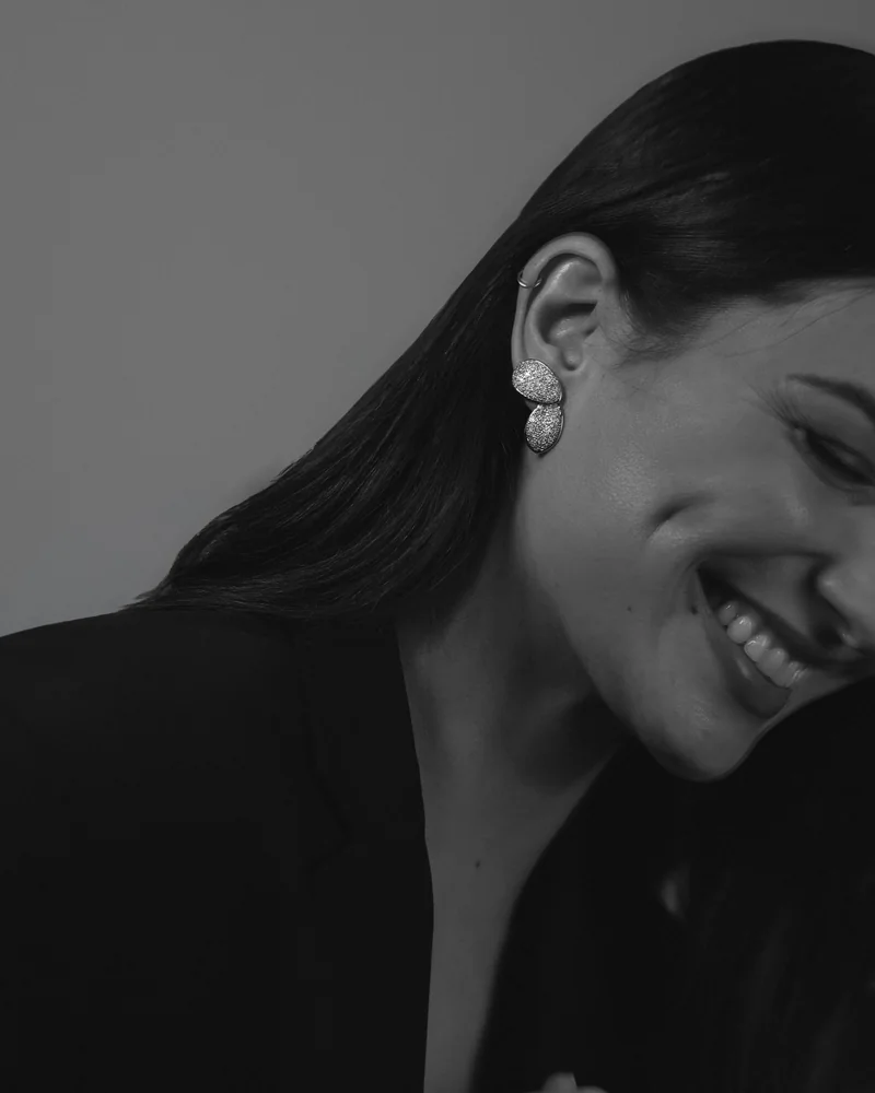 Woman laughing while wearing sculptural pavé earrings